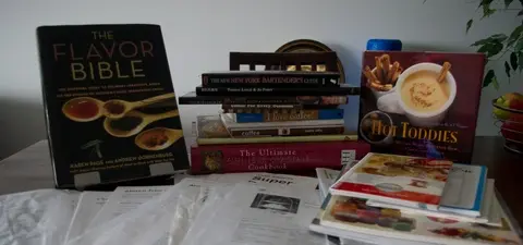 collection of cookbooks and recipes printed from the internet