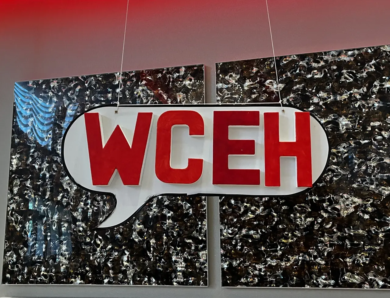 Sign hanging in the shape of a speech bubble that reads “WCEH”, which is short for “WordCamp Eh?”